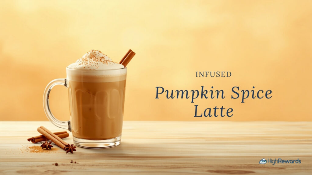 A creamy infused pumpkin spice latte in a glass mug with cinnamon sticks and star anise on a light wood surface